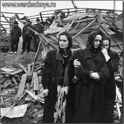 Women and men gather at a funeral site where Russian plan...